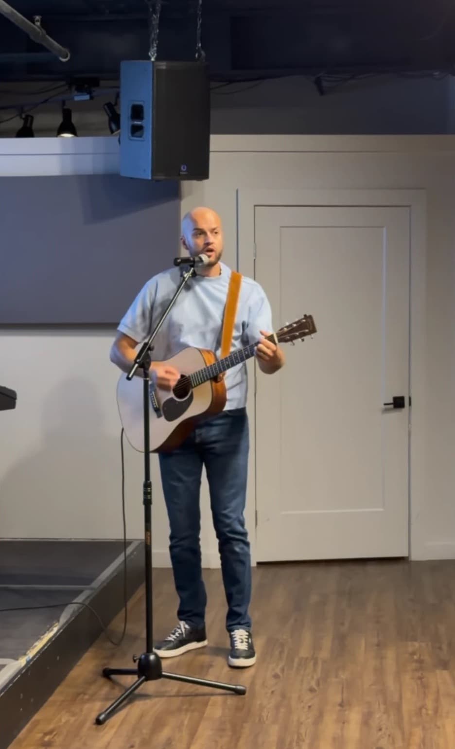 A brother leading worship with an acoustic guitar