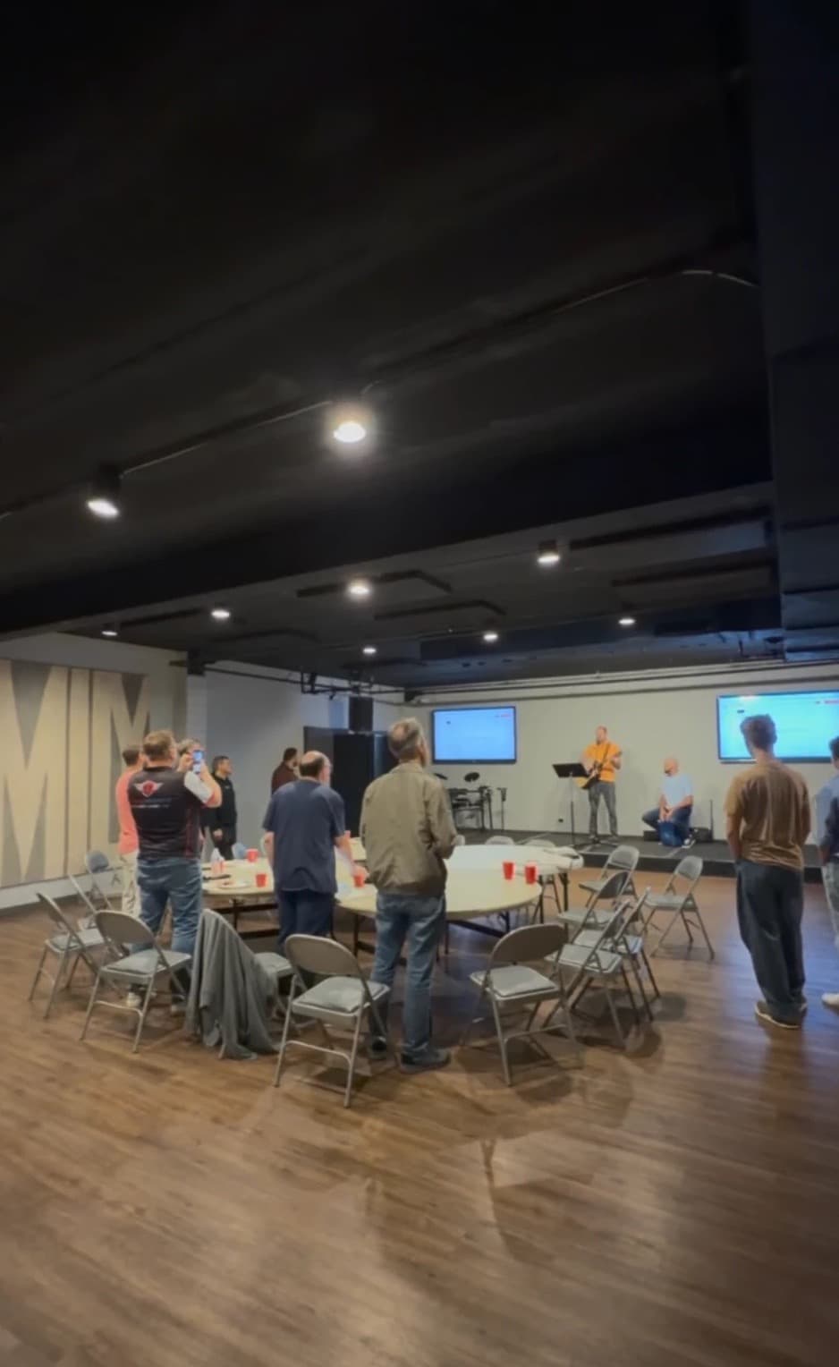 Men standing in worship around the breakfast tables